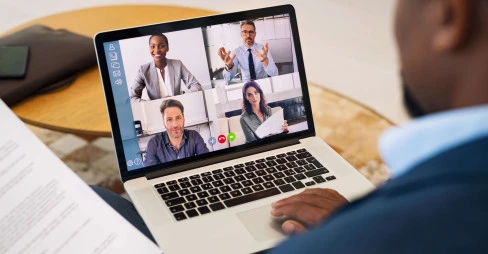 split screen of four people on video call on laptop